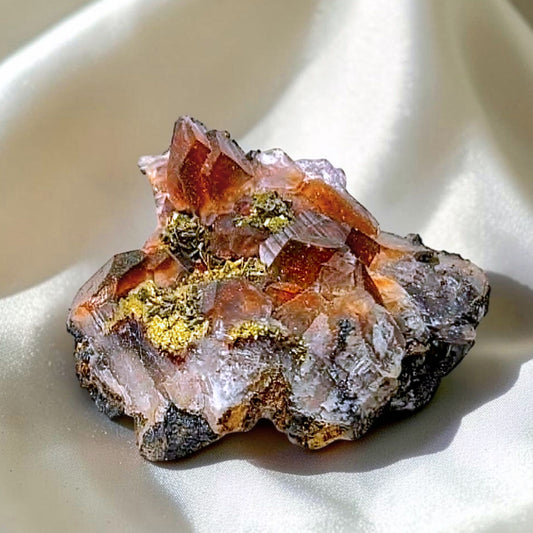 Red Calcite crystal specimen with metallic gold Chalcopyrite inclusions from Dayao County, China on satin