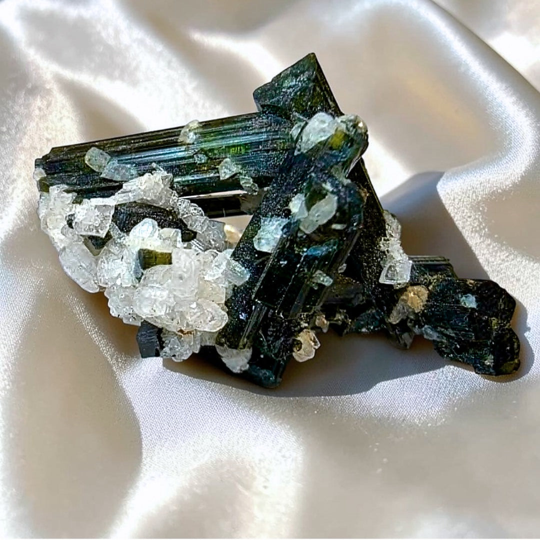 Green elbaite tourmaline crystals on white albite mineral specimen from Minas Gerais, Brazil.