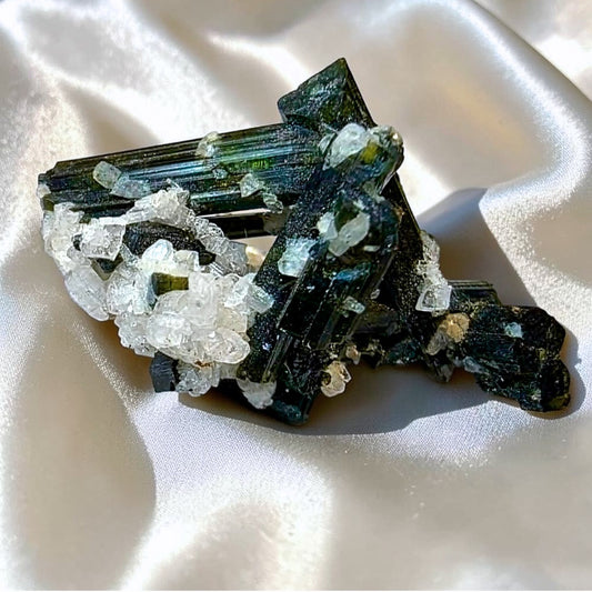 Green elbaite tourmaline crystals on white albite mineral specimen from Minas Gerais, Brazil.