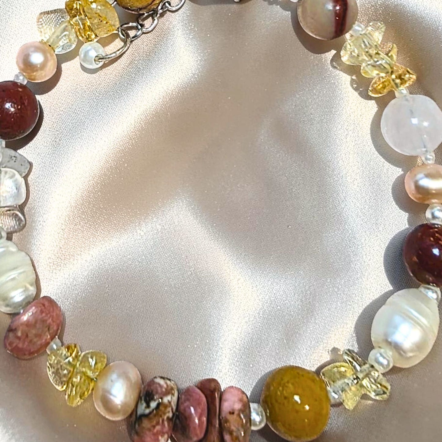 Close up view of natural polished citrine beads and banded Australian mookaite jasper on a handmade stretch crystal bracelet from Melbourne.