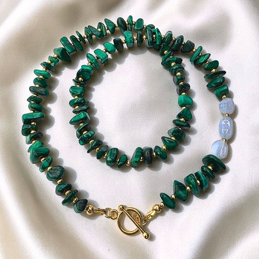 Malachite chip necklace with blue lace agate nugget beads and gold toggle clasp on satin background