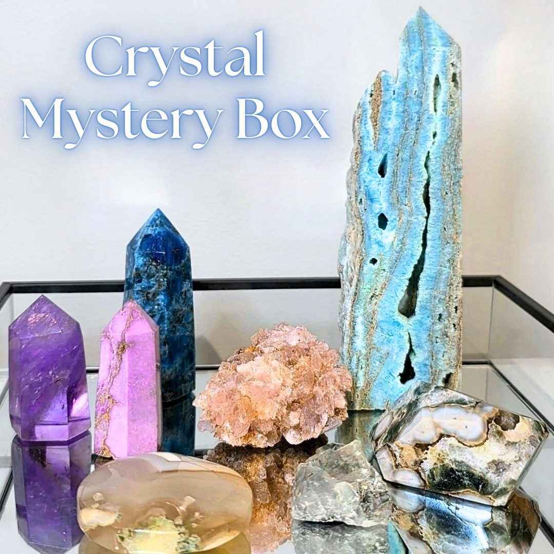 Collection of crystals and geodes with 'Crystal Mystery Box' text on a reflective surface.