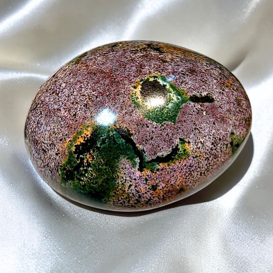Purple and green Ocean Jasper palm stone with natural orbicular patterns from Madagascar.